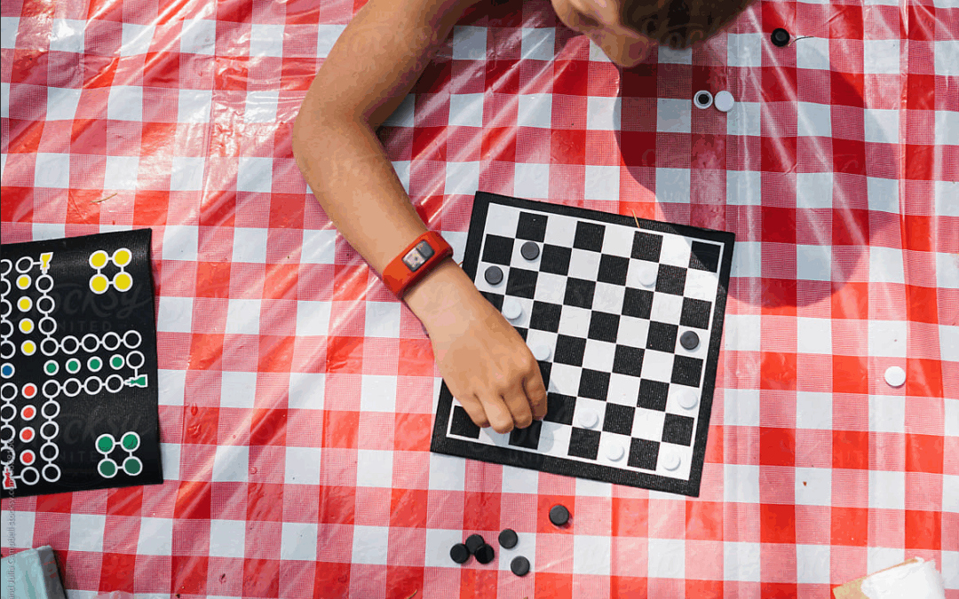 Boy Playing Chess on Picnic Blanket